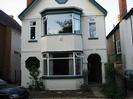 White rendered house with large bay windows.