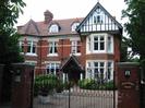 Lansdowne Court.
Three-storey house of dark red brick with white-painted window-frames (some with stone surrounds).
Red tile roof with dormer windows.
Tall brick pillars supporting iron gates.