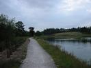 Wide footpath with river on the right and bank of small trees on left.
Roofs and chimneys of Taplow Court visible on the skyline.