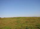 Open field with iron fence on the skyline.