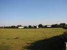 Open field with houses in the distance.