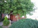 Brick-built house seen through bushes.