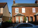 Pair of red-brick houses with rectangular bay windows.