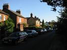 Looking south on Hitcham Road.
Red brick houses on the left.
The black and white building at the end of the road is The Maypole public house.