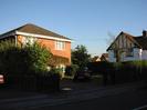 Footway and hedges with brick house beyond.
Part of the Maypole public house visible on the right.