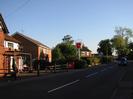 Looking south on Hitcham Road.
Part of the Maypole public house on the left.
Courage brewery sign.
Houses visible over hedges.