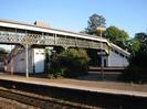Island platform with covered iron footbridge connecting it to outer platforms.
