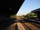 On platform with overhanging canopy.
Rails on right with island platform beyond.
Trees in background.