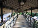 Looking south across the footbridge.
Corrugated metal roof with decorative wooden boarding each side.
Iron lattice bridge structure
Strong shadows across bridge deck caused by low sun.
Steps down to platforms 2 and 3 on left.