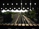 Looking west from the footbridge into the setting sun.
Part of bridge roof at top of picture.
Sun glinting off the relief line below.
Main line on left joins with relief line in the distance.
Iron girder with rivets forming handrail at bottom of picture.