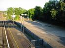 Platform 1 with iron railings and car park.
Trees on right.