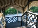 Steps down at southern end of footbridge.
Corrugated steel roof with decorative wooden boards.
Iron lattice bridge structure.