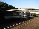Station with covered iron footbridge.
High Speed Train passing on main line.