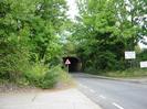 Looking north on Station Road.
Trees on both sides, with railway bridge in the background.
Roadsign warning of junctions.
Signs on right for G&W Motor Company and Marble Magic.