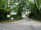 Looking across Station Road at the entrance to a small trading estate.
Trees either side.
Signs for G&W Motor Company and for Marble Magic.