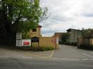 The entrance to Bishops Gate.
Sandy-coloured brick walls with large metal gate.
Signs on walls.