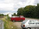 Railway on left.
Metal fence and car-park.
Trees on right.