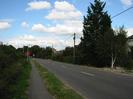 Looking north on Marsh Lane.
Bushes and verge on left with tarmac footpath.
Roadsigns in verge.
Bushes and trees on right, with telephone poles.