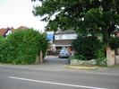 Looking across Marsh Lane into the driveway of a modern house.
Scaffolding around the house. A car in the driveway.