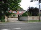 Portland: House built of sand-coloured brick with red tile-hung upper floor.
Brick wall with decorative patterns and wrought-iron gates.