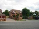 Road in the foreground.
Brick walls, driveways, and houses in the background.