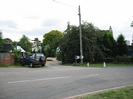 Road in the foreground.
Car and driveways in the background.
Chevron sign warning of sharp bend in the road.