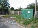 Green roadside cabin.
Tarmac apron with linear drains.
Wooden fences.