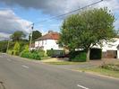 Road on left.
Driveways and houses on right, with trees in front.