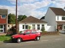 Flintstone: white bungalow with tile roof.
Road with red car.