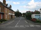 Looking into Ye Meads from Marsh Lane.
Large brick building on the left.
White painted garage with light blue door on the right.