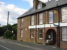 Building of patterned brickwork with slate roof.
Central arched entryway.
External drainpipes.