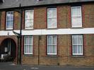 Brick building with arched entryway.
White painted sash windows.