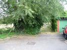 Road end with tree and gate.
Car and garage to the right.