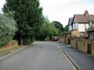 Looking east on Ye Meads.
Road with footway on each side.
Wall with trees on left.
Walls with houses on right.