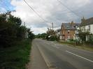 Looking north on Marsh Lane.
Road with footway and trees on the left.
Houses on the right.