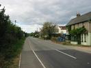 Looking north on Marsh Lane.
Hedge and footway on left.
Road with houses on the right.