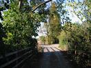 Narrow lane with trees on both sides.
Road junction with bridge on left.