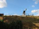 Railway embankment with retaining wall in sandy brick.
Railings and signals on top of embankment.