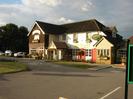 The Dumb Bell.
Pub and Harvester restaurant: two-storey building with dark tiled roof.
Car-park and grassy areas in front of pub.