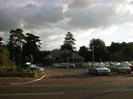 Looking south across the Bath Road.
Altwood Mini dealership with cars on the forecourt.
Building and trees in the background.