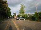 Looking east along Approach Road.
Tall trees on the left.
Station car-park on the right.
Station buildings in the distance.