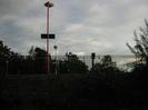 Embankment with iron railing fence and station lights.